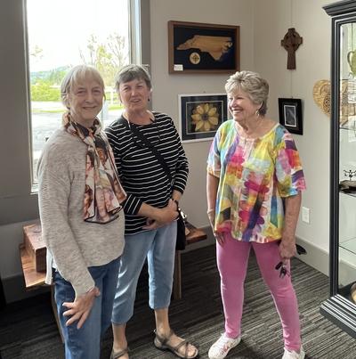 Three smiling women in art gallery